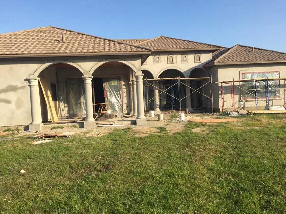 A house is being built in the middle of a grassy field.