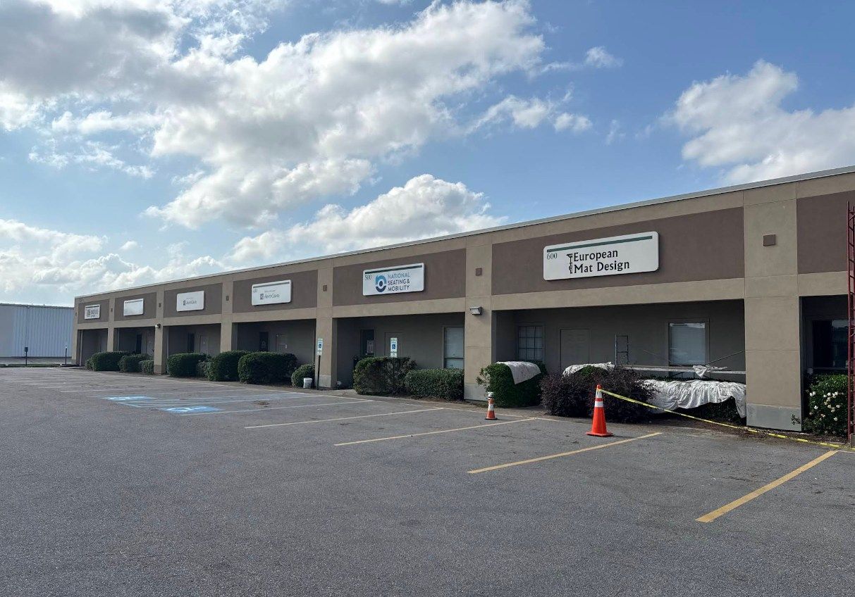 A large building with a lot of windows and a parking lot in front of it.