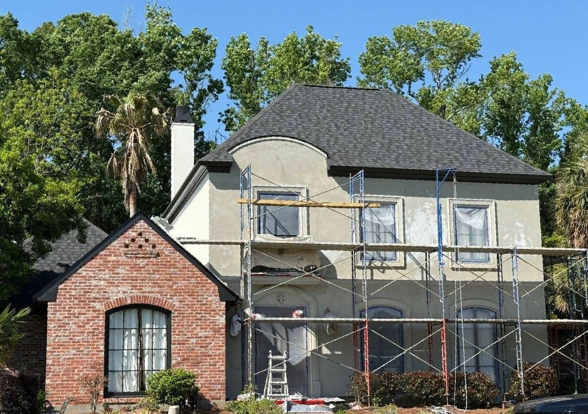 A large house with scaffolding around it is being painted.