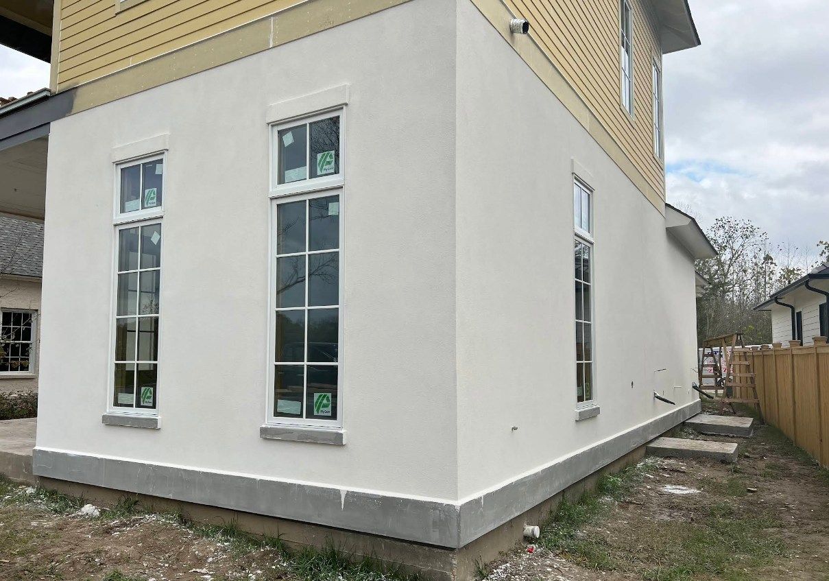 A white house with a lot of windows is being built.