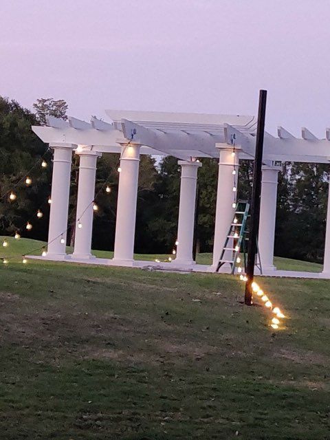 A pergola is being built with columns and lights.