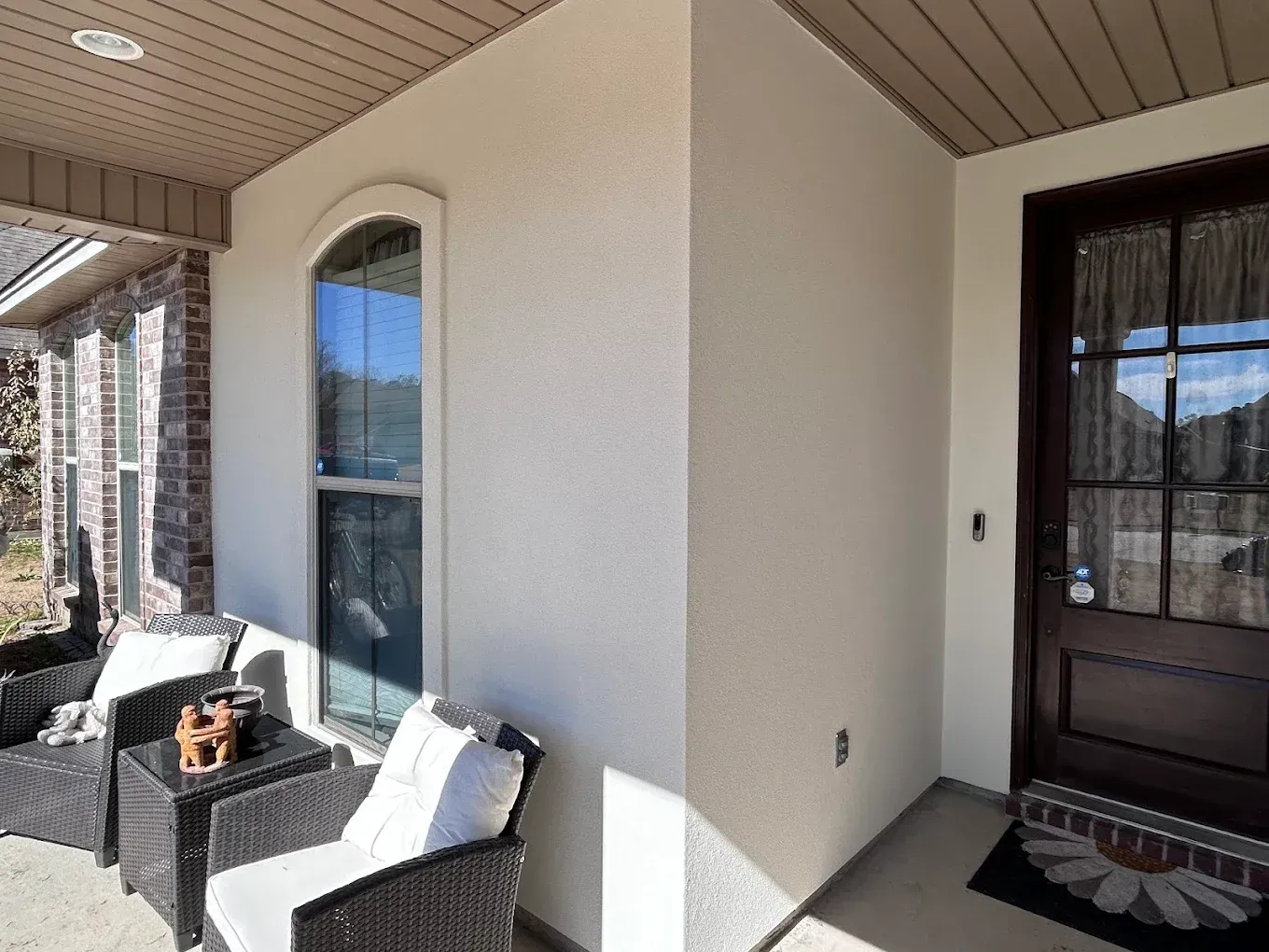 Exterior house entrance with a window, door, and seating area.