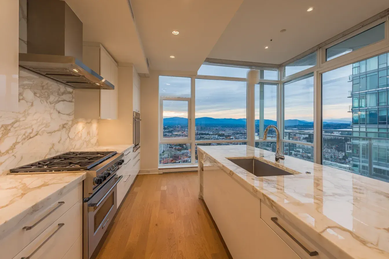 Kitchen renovation Coquitlam BC | Kitchen remodel Coquitlam Canada | White quartz island, LED spotlights, and decorative tile walls. Coquitlam remodelers merge innovation with trusted building methods. Every detail creates a modern yet timeless interior.