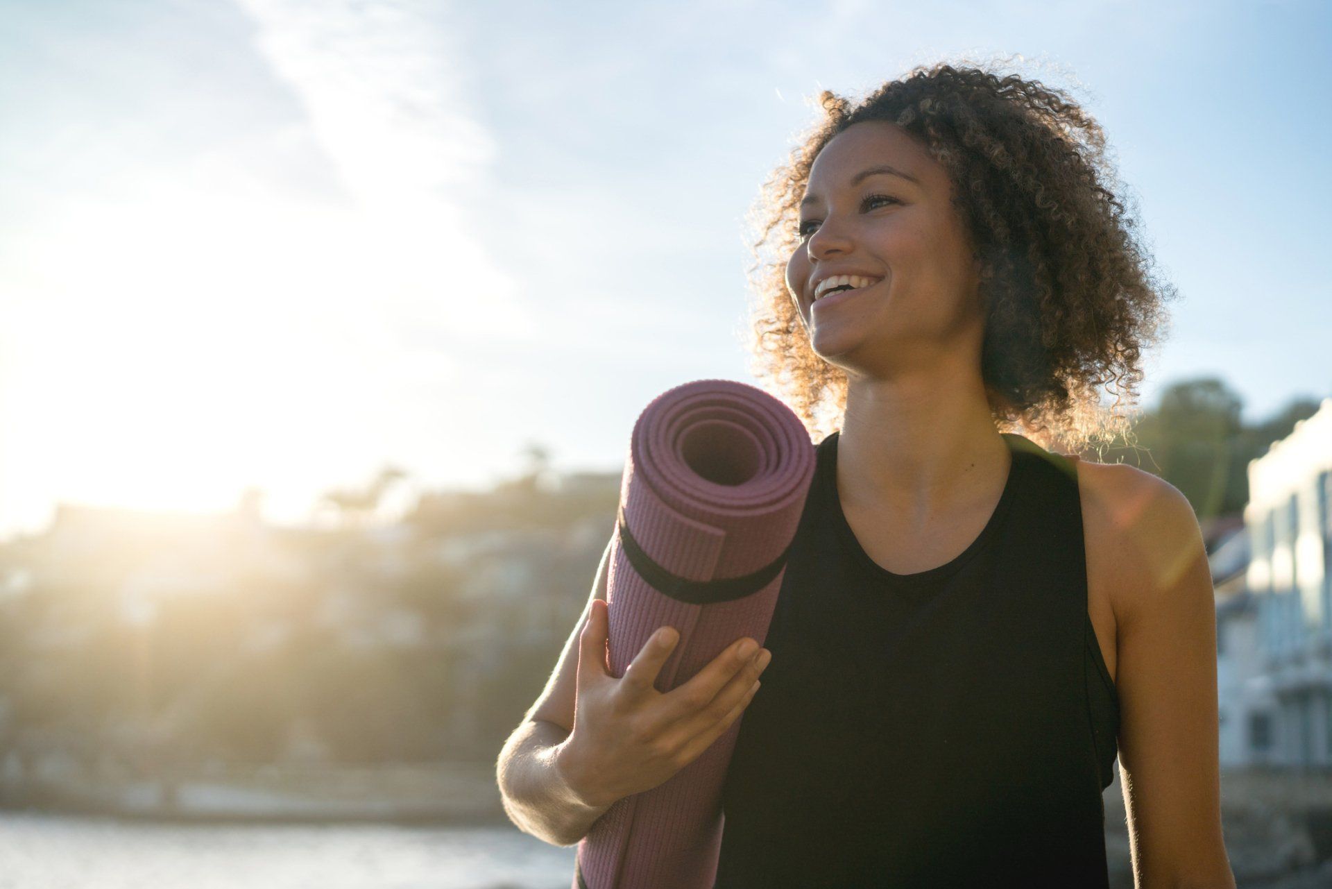 Happy woman with yoga mat | Cleveland, OH | Healthy Solutions Inc