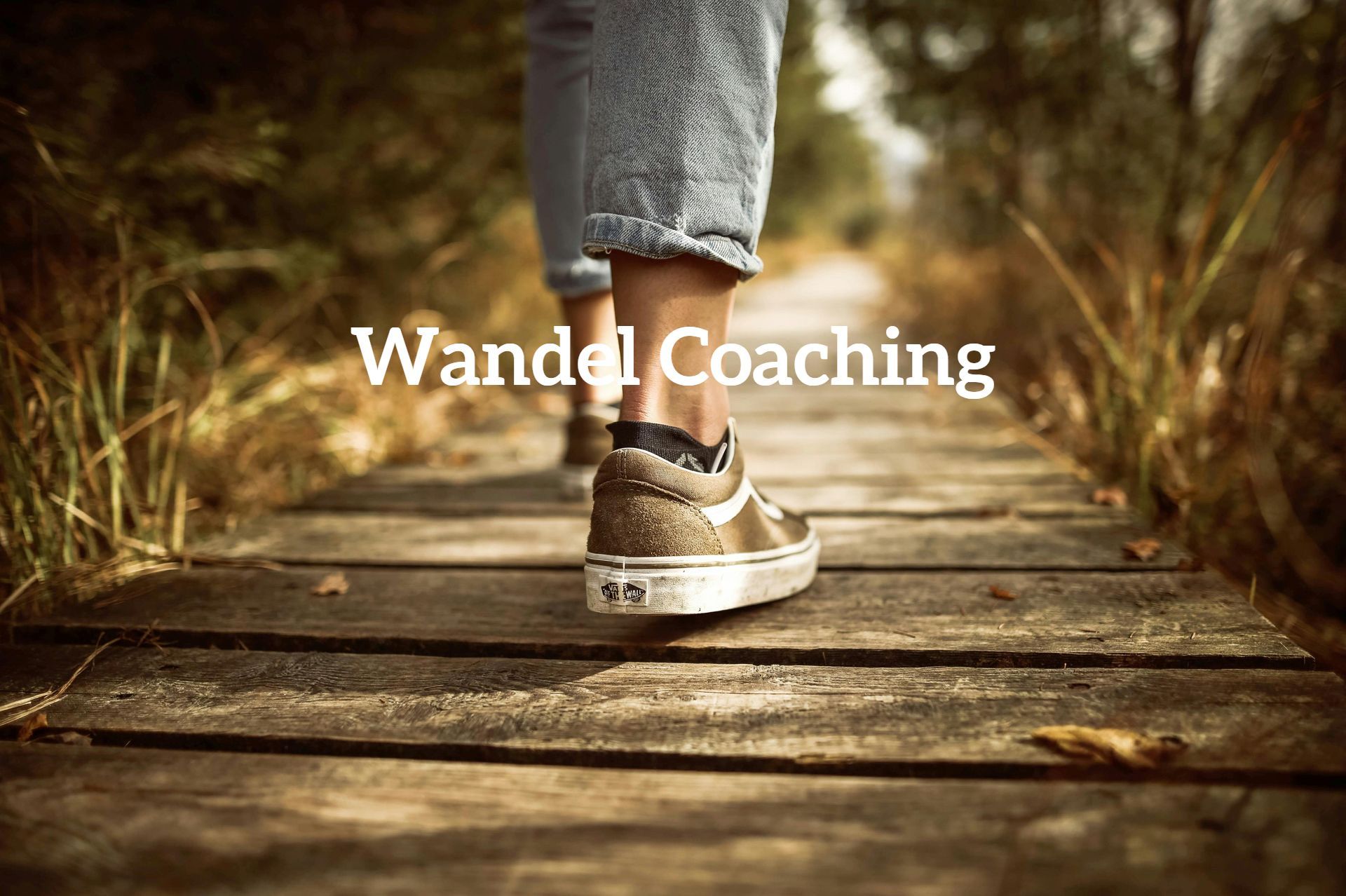 Een persoon loopt over een houten vlonderpad in een bos, met de tekst