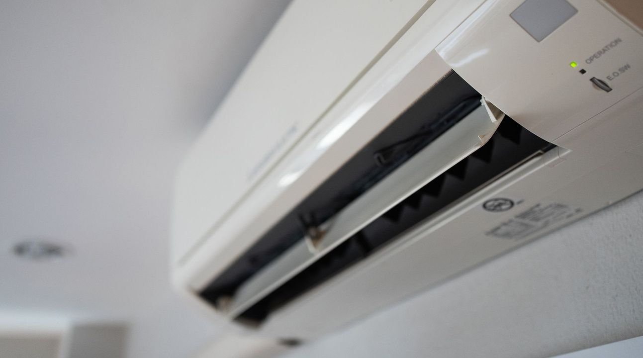 Condizionatore d'aria bianco montato su un soffitto bianco.