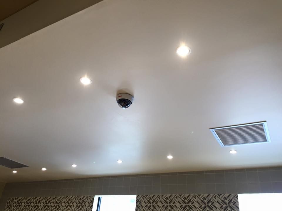 Soffitto con telecamera di sicurezza, luci da incasso e presa d'aria.