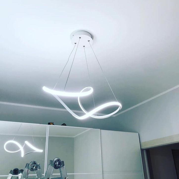 Lampada da soffitto a LED bianca e vorticosa che illumina una stanza.