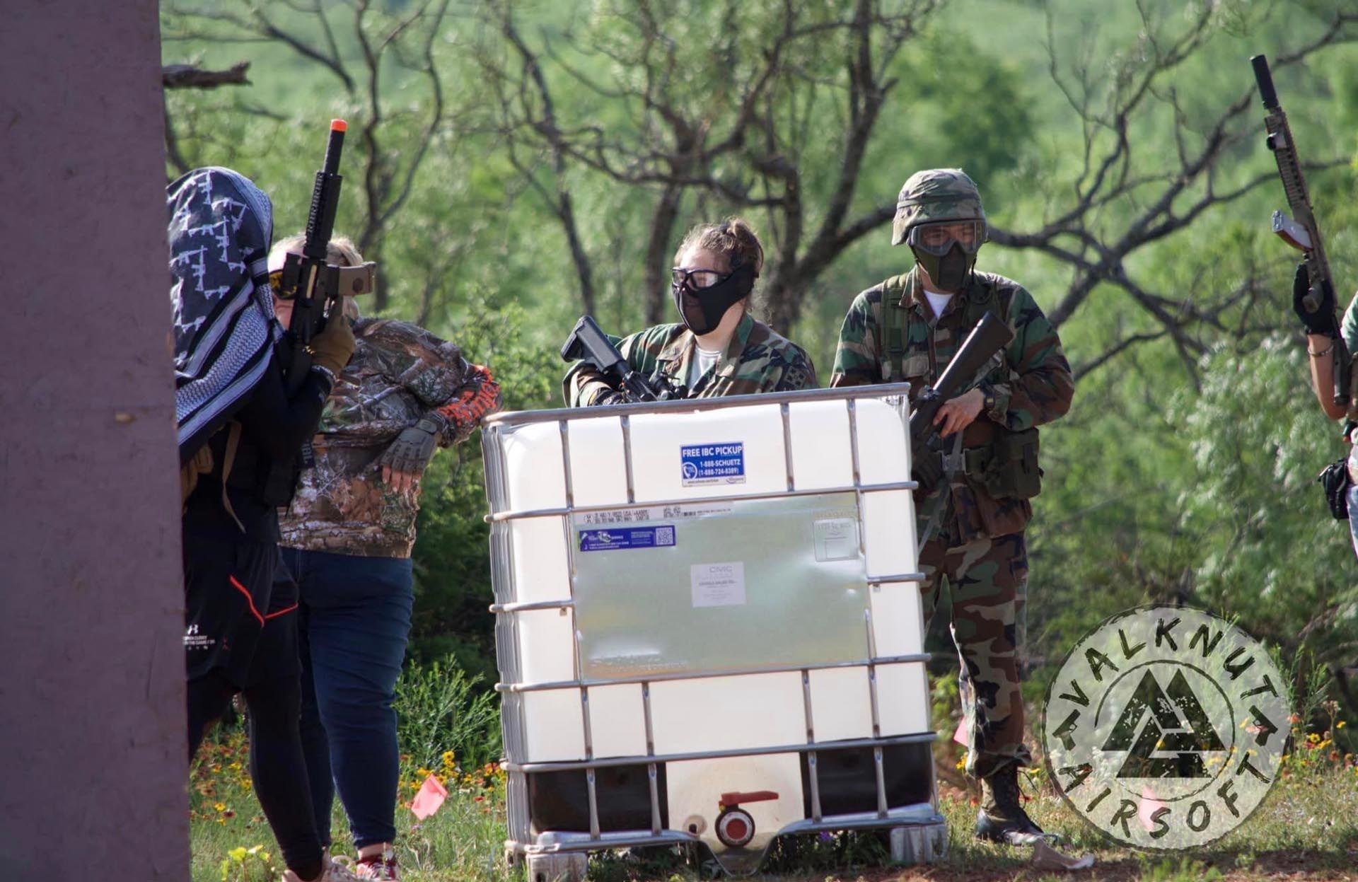 A group of people are standing around a large white tank