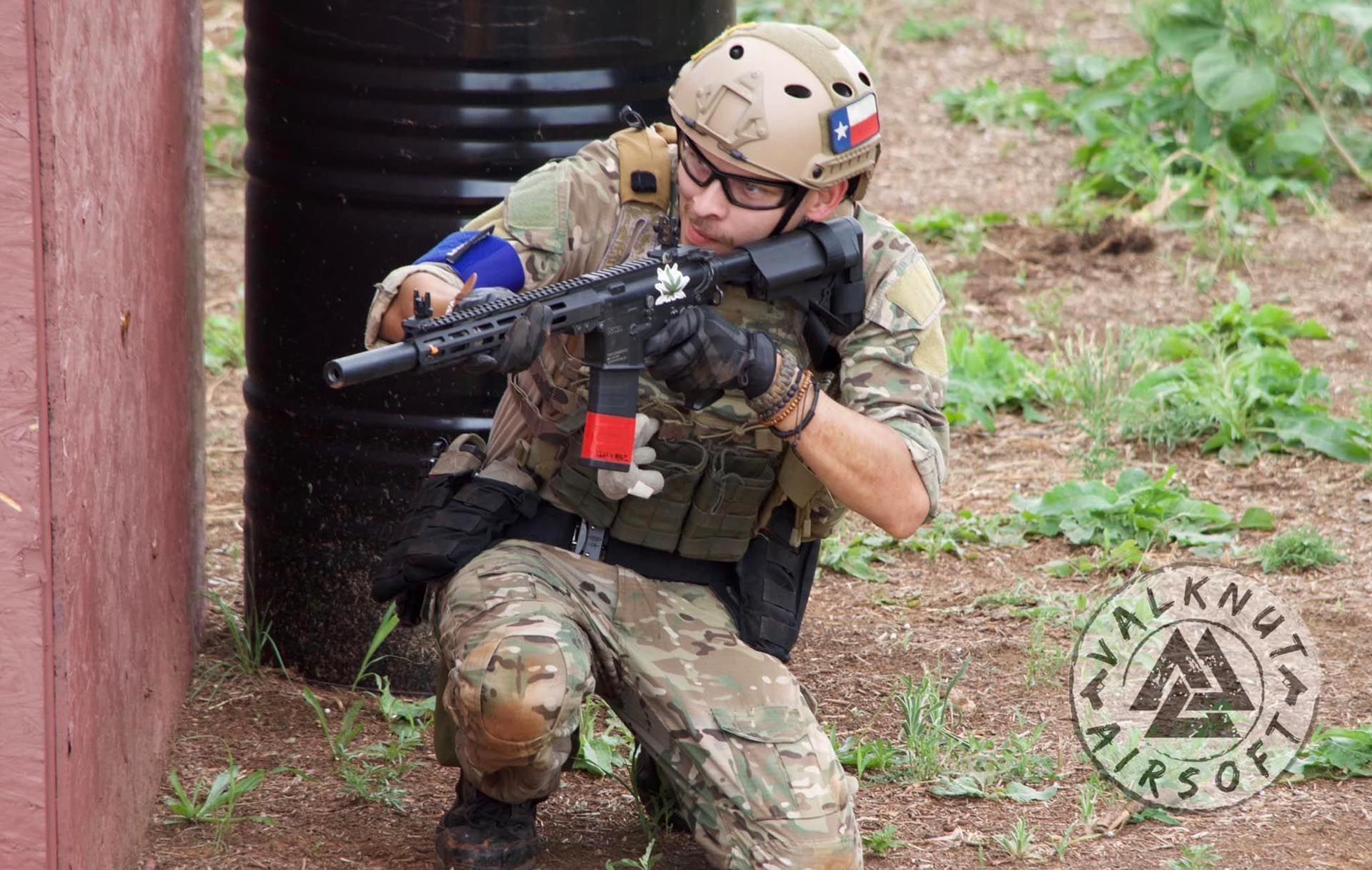 Airsoft player waiting beside the wall