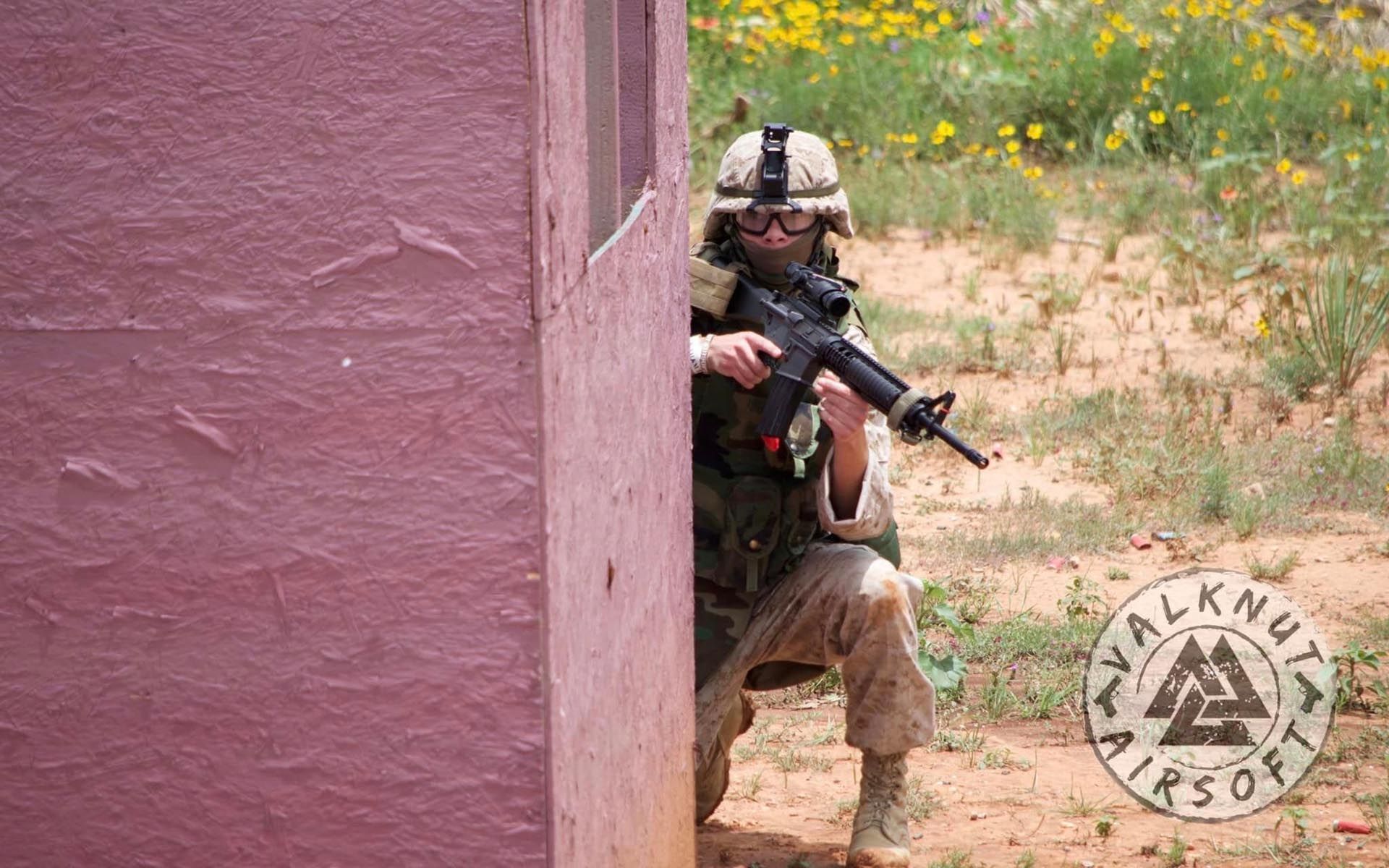 Airsoft player hiding beside the wall