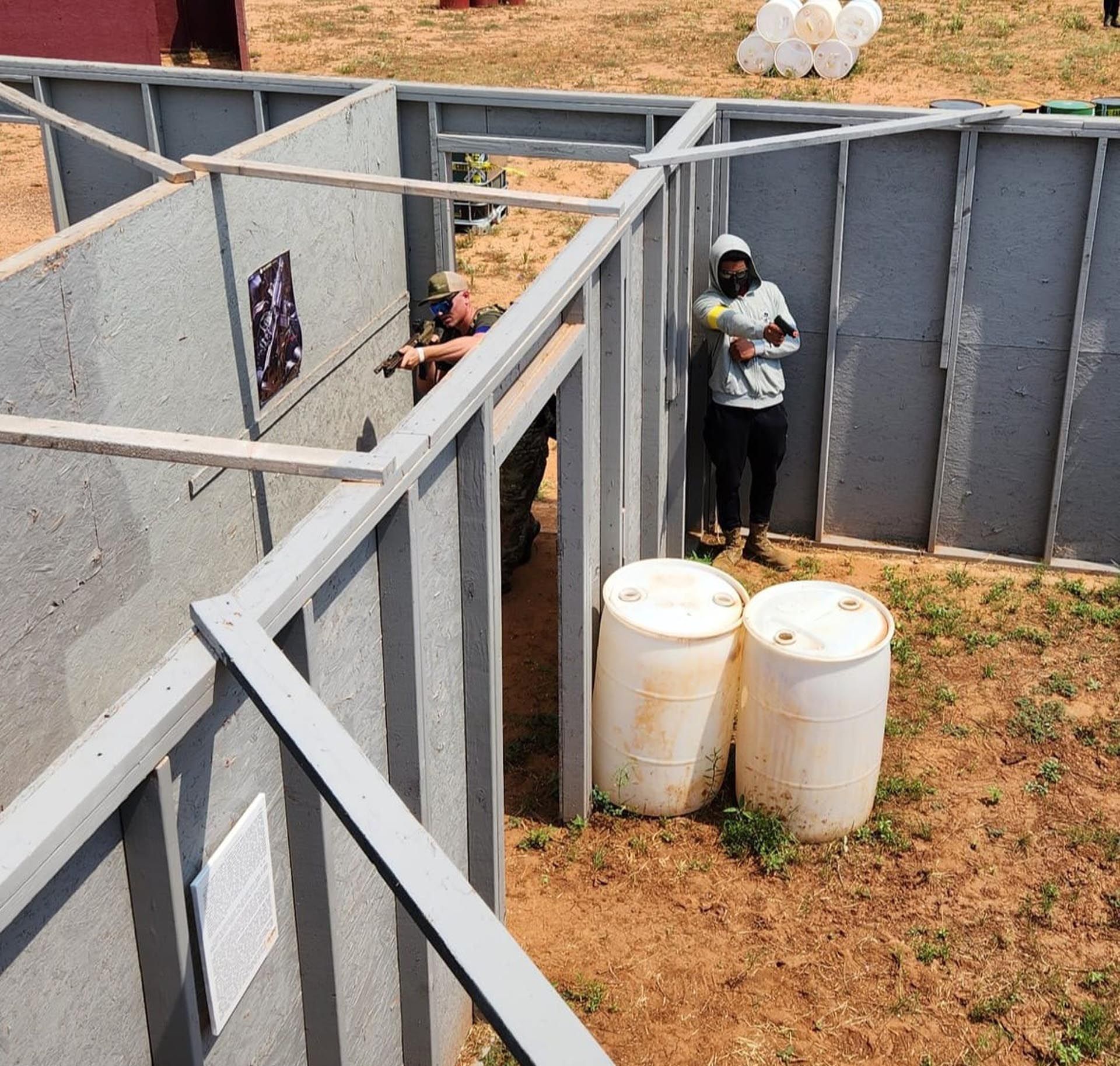 A man is standing in a maze with two barrels in front of him
