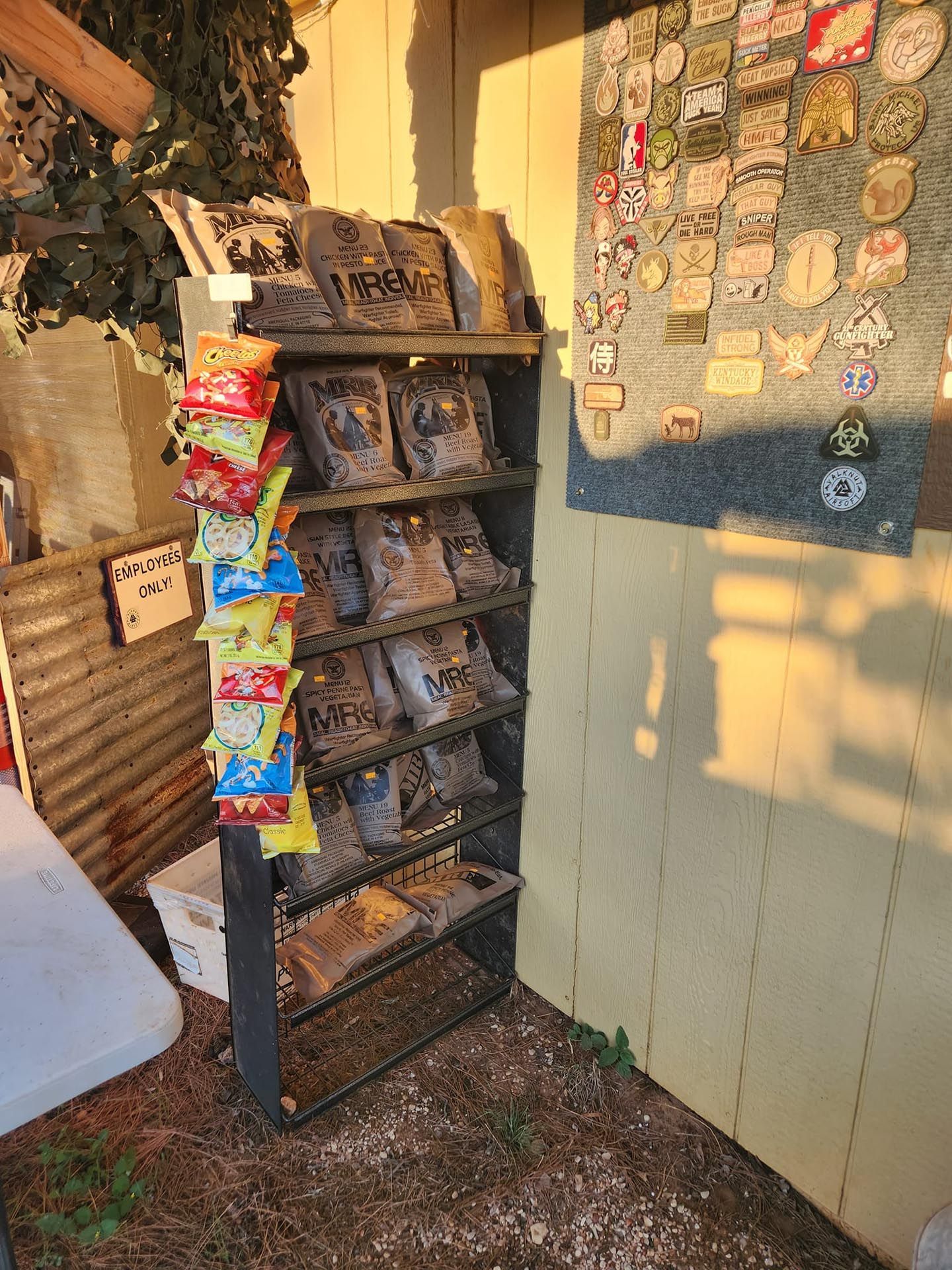 A shelf filled with bags of chips next to a wall with stickers on it