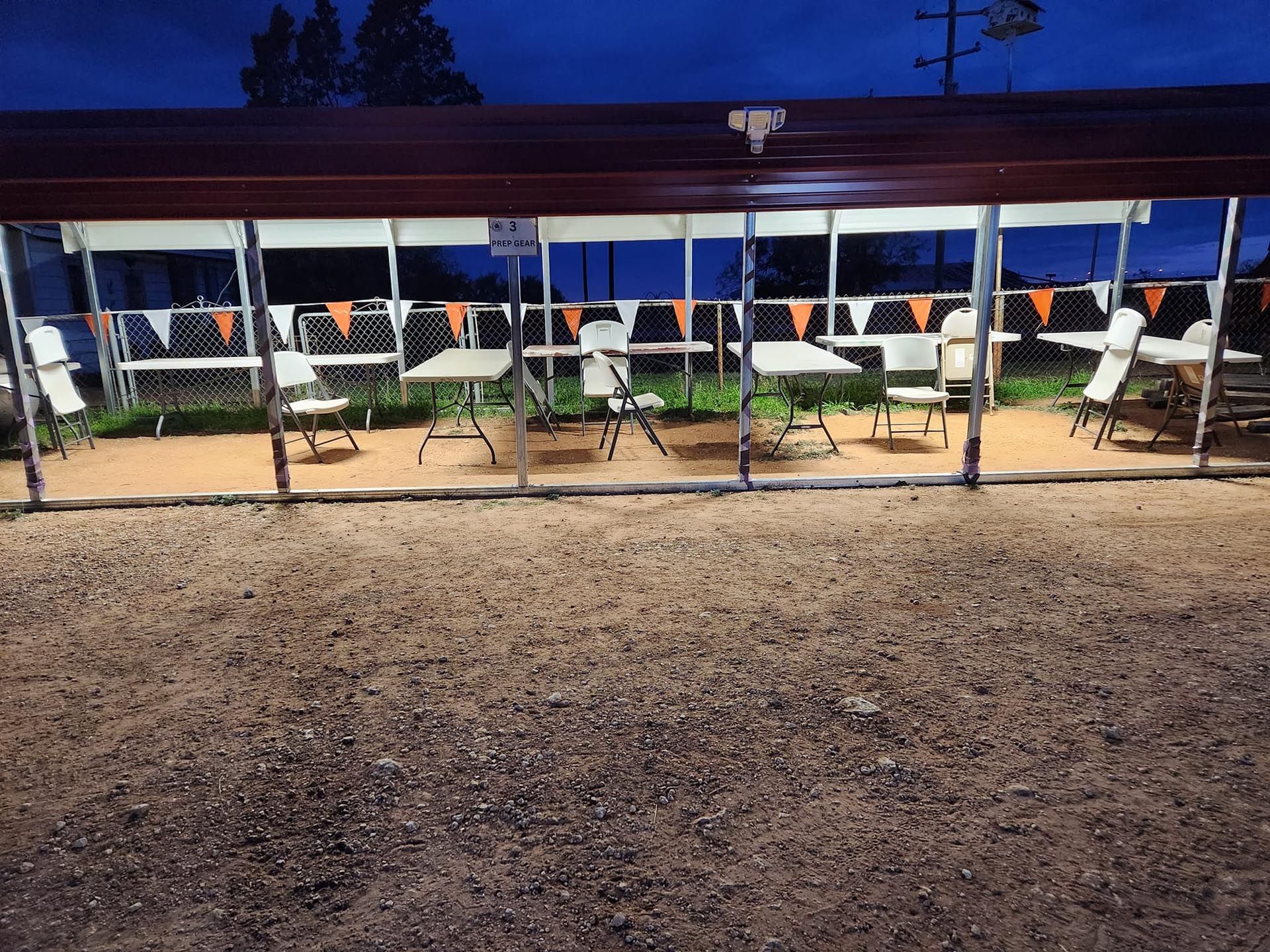 A row of tables and chairs under a tent