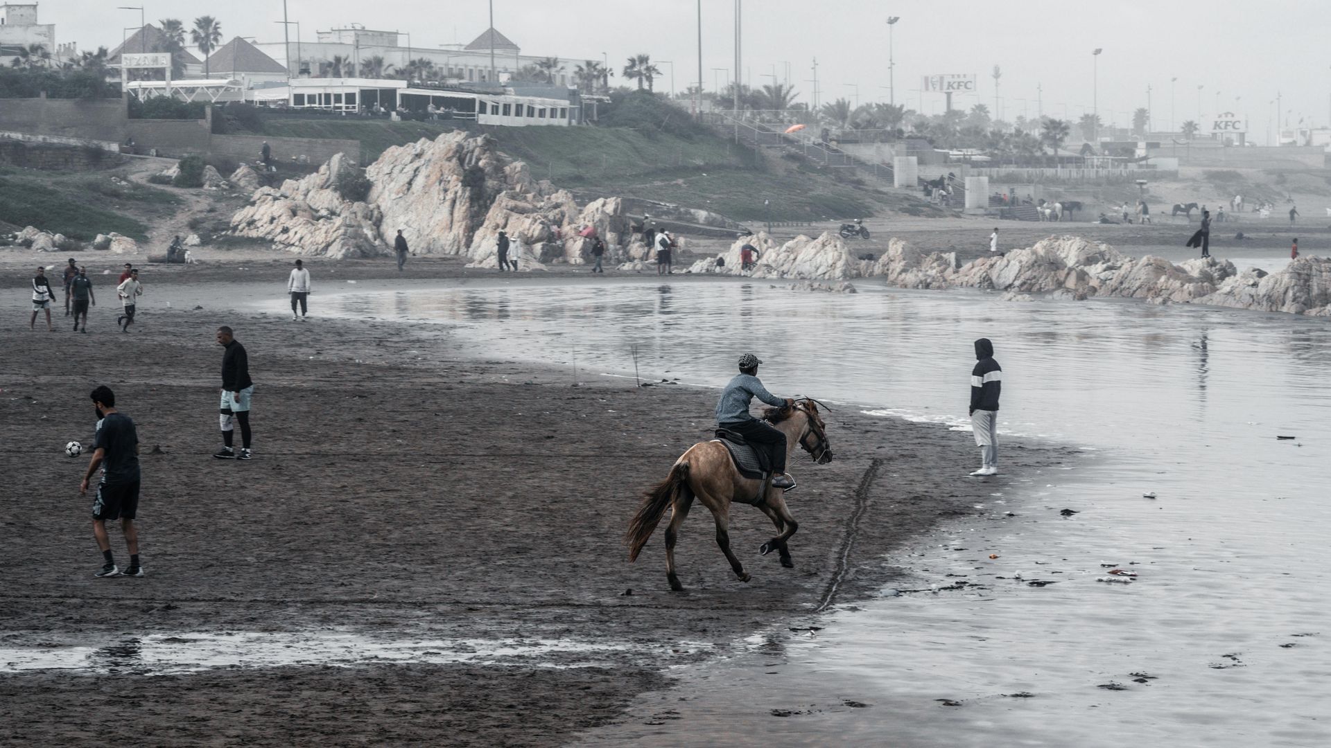 Un homme à cheval sur une plage boueuse