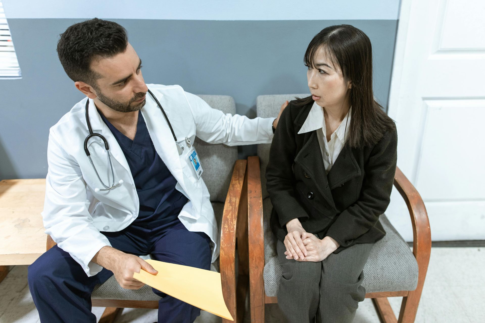 Un médecin parle à un patient dans une salle d'attente.