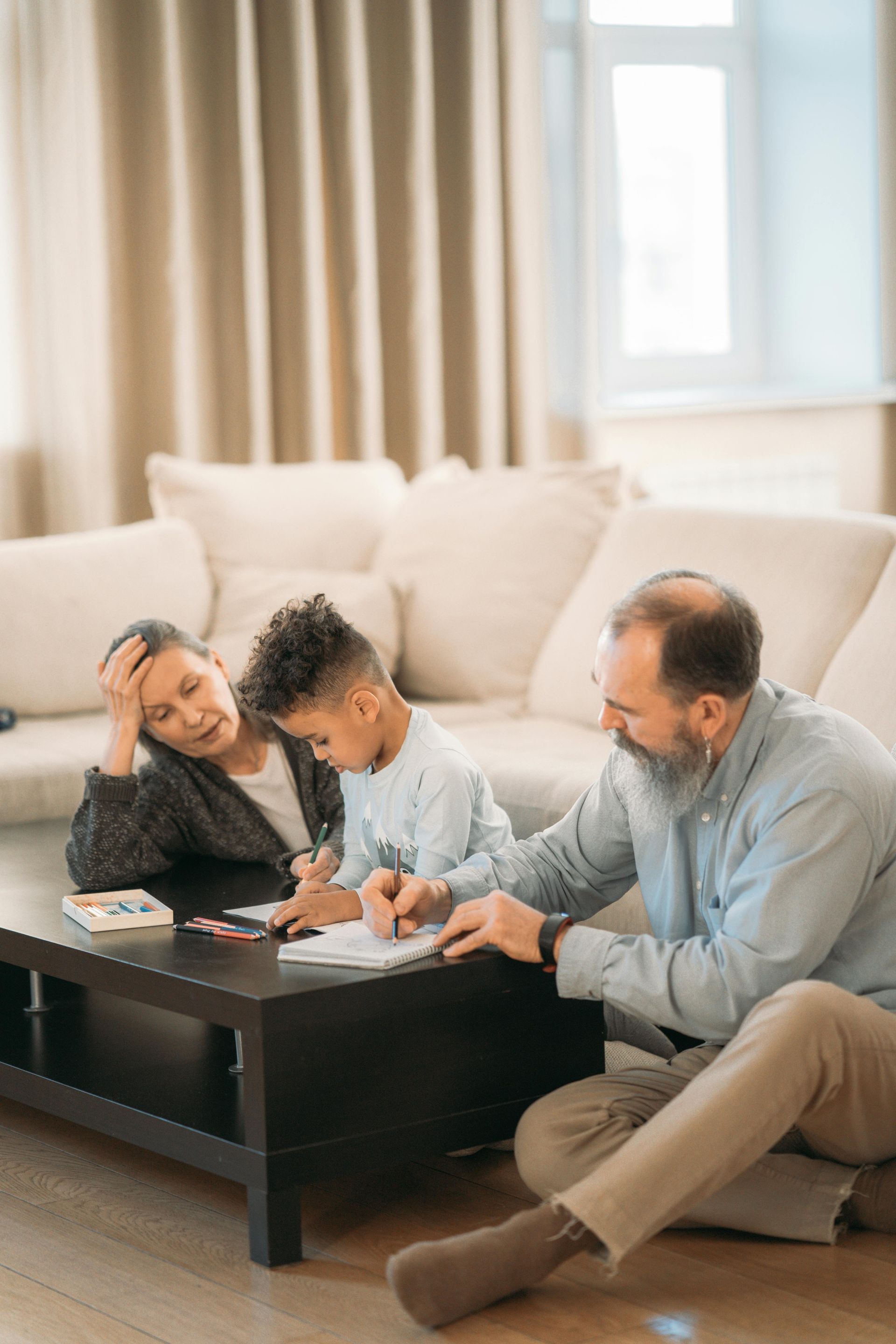Un homme, une femme et un enfant sont assis à une table dans un salon.