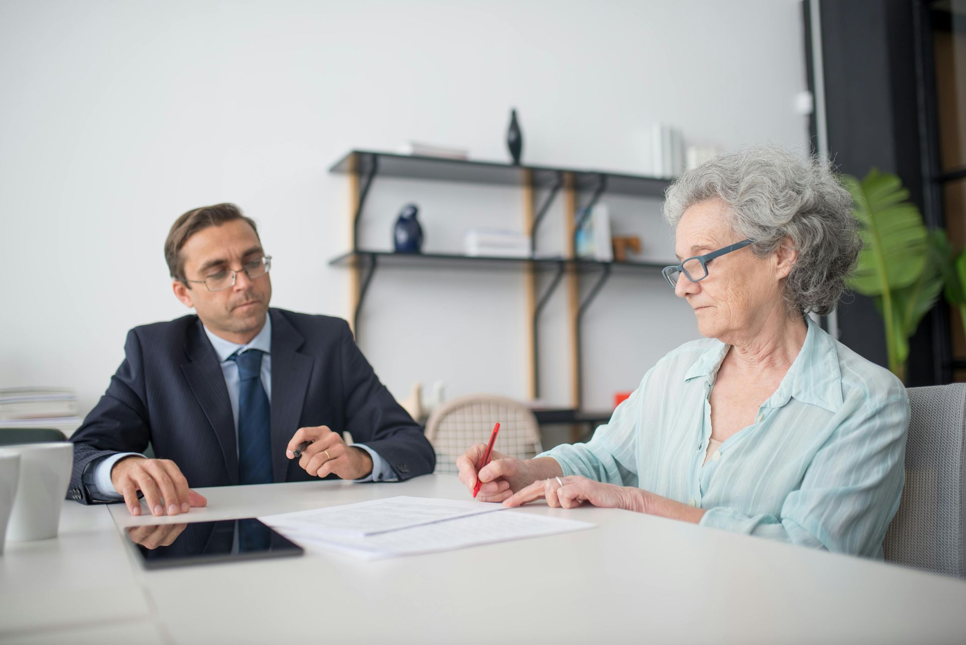 Un homme et une femme sont assis à une table et signent un document.