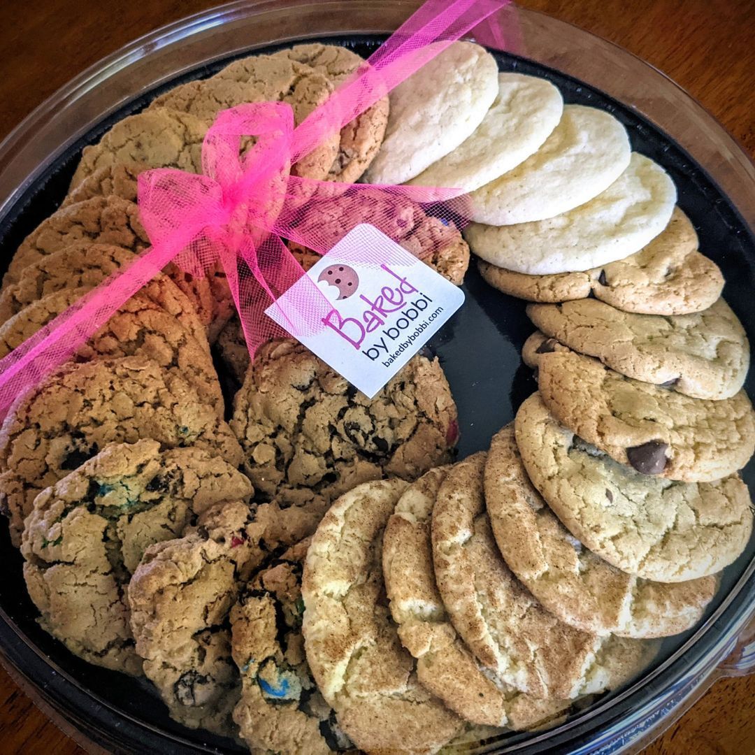A tray of baked cookies with a pink bow