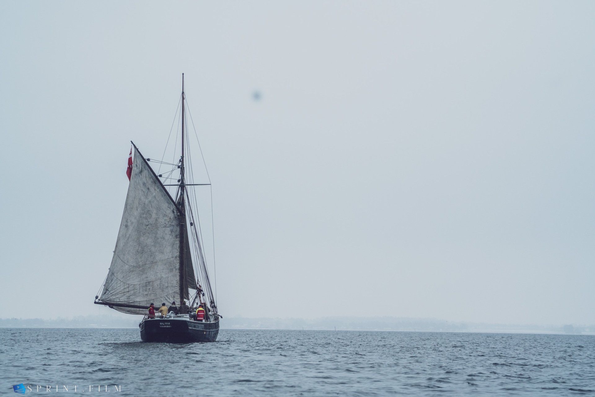 En sejlbåd flyder oven på en vandmasse.