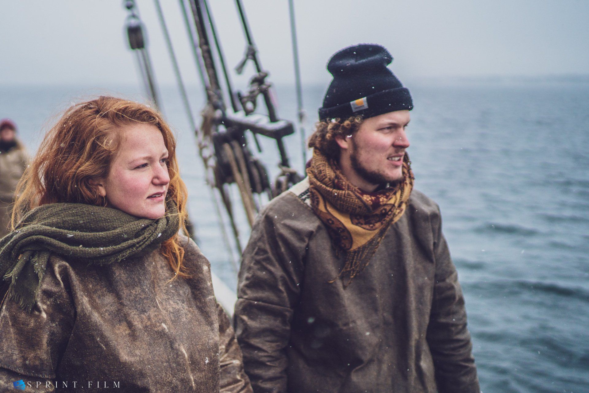 En mand og en kvinde står på en båd i havet.