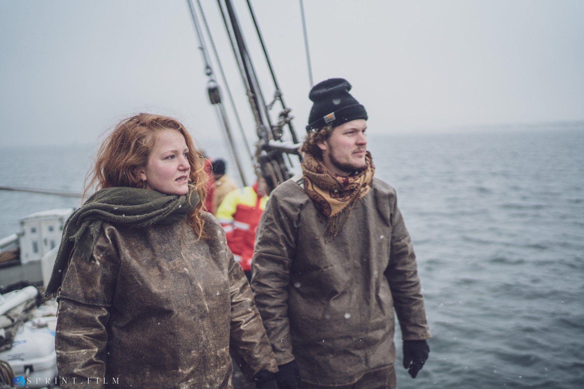 En mand og en kvinde står på en båd i havet.