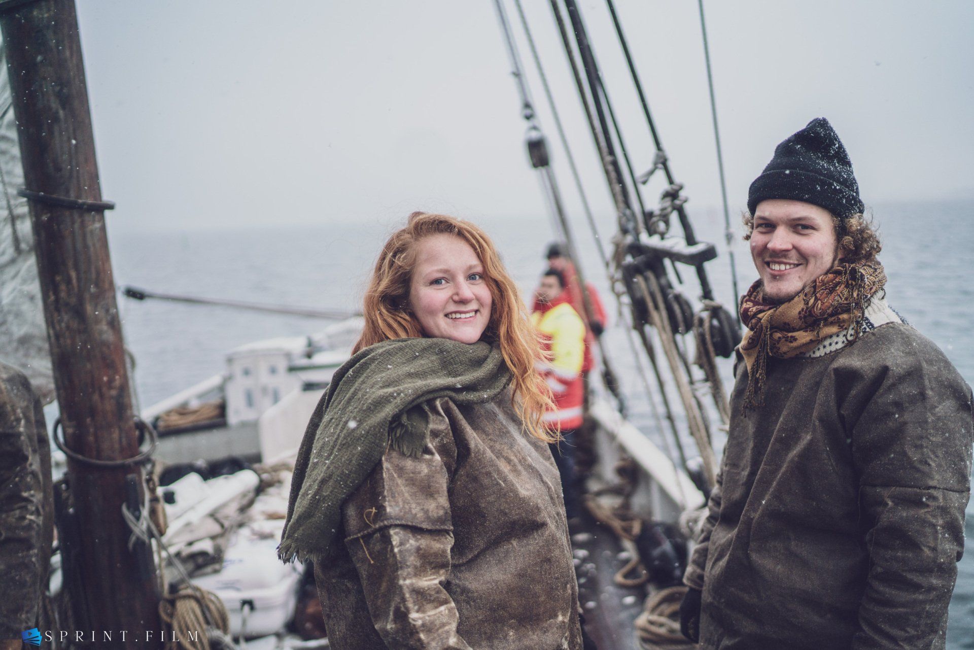 En mand og en kvinde står på en båd i havet.