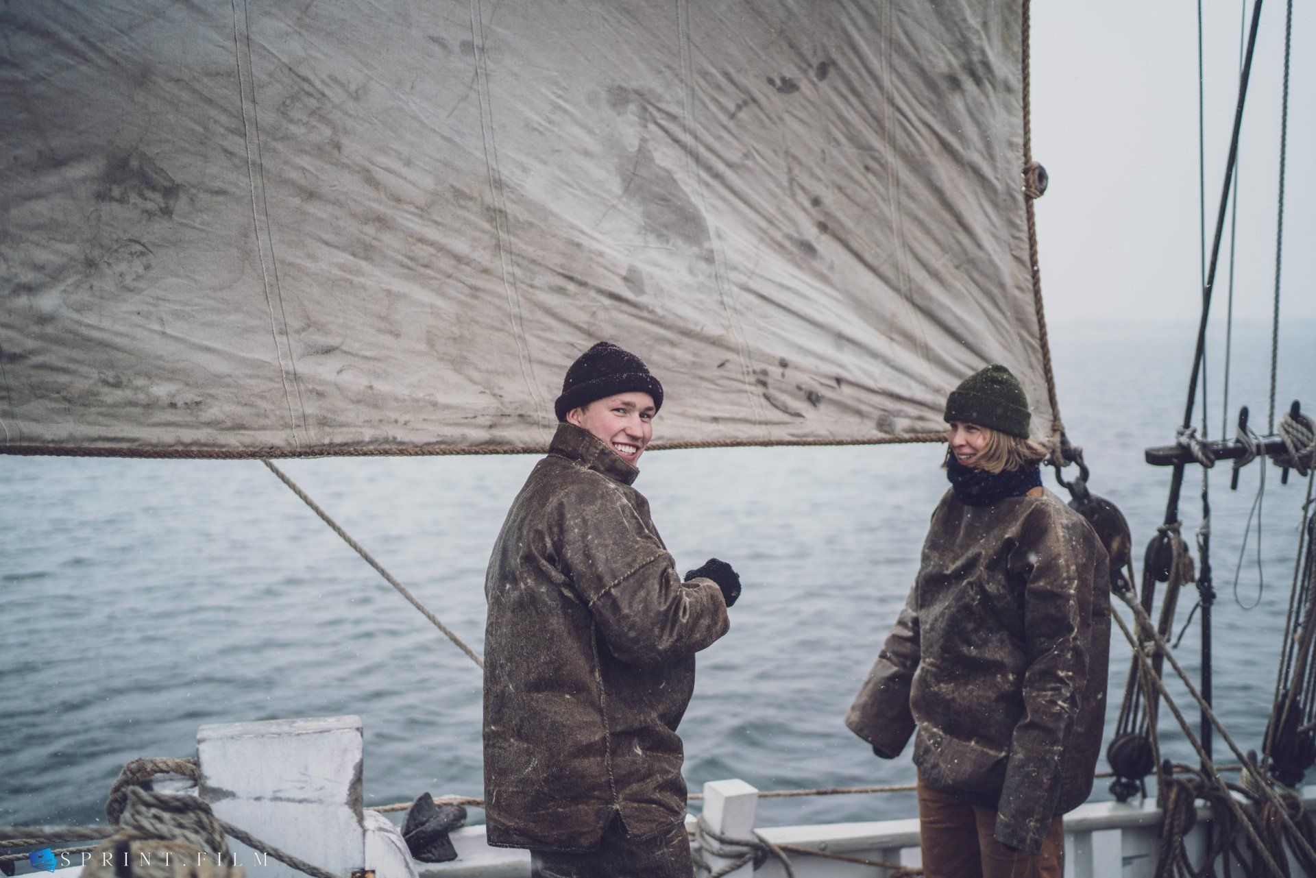 En mand og en kvinde står på en båd i vandet.