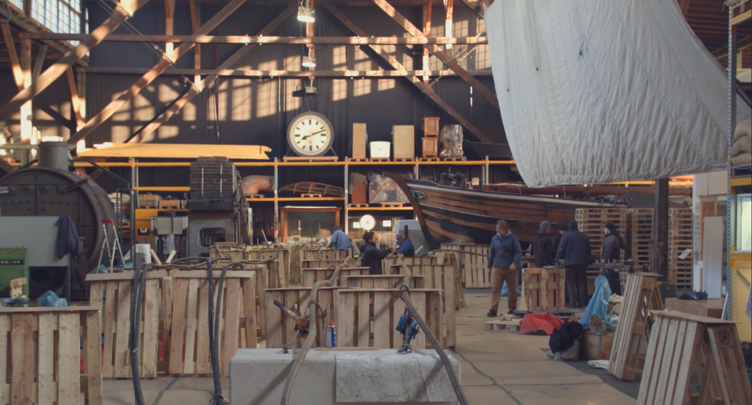 Et lager fyldt med masser af trækasser og et ur på væggen.