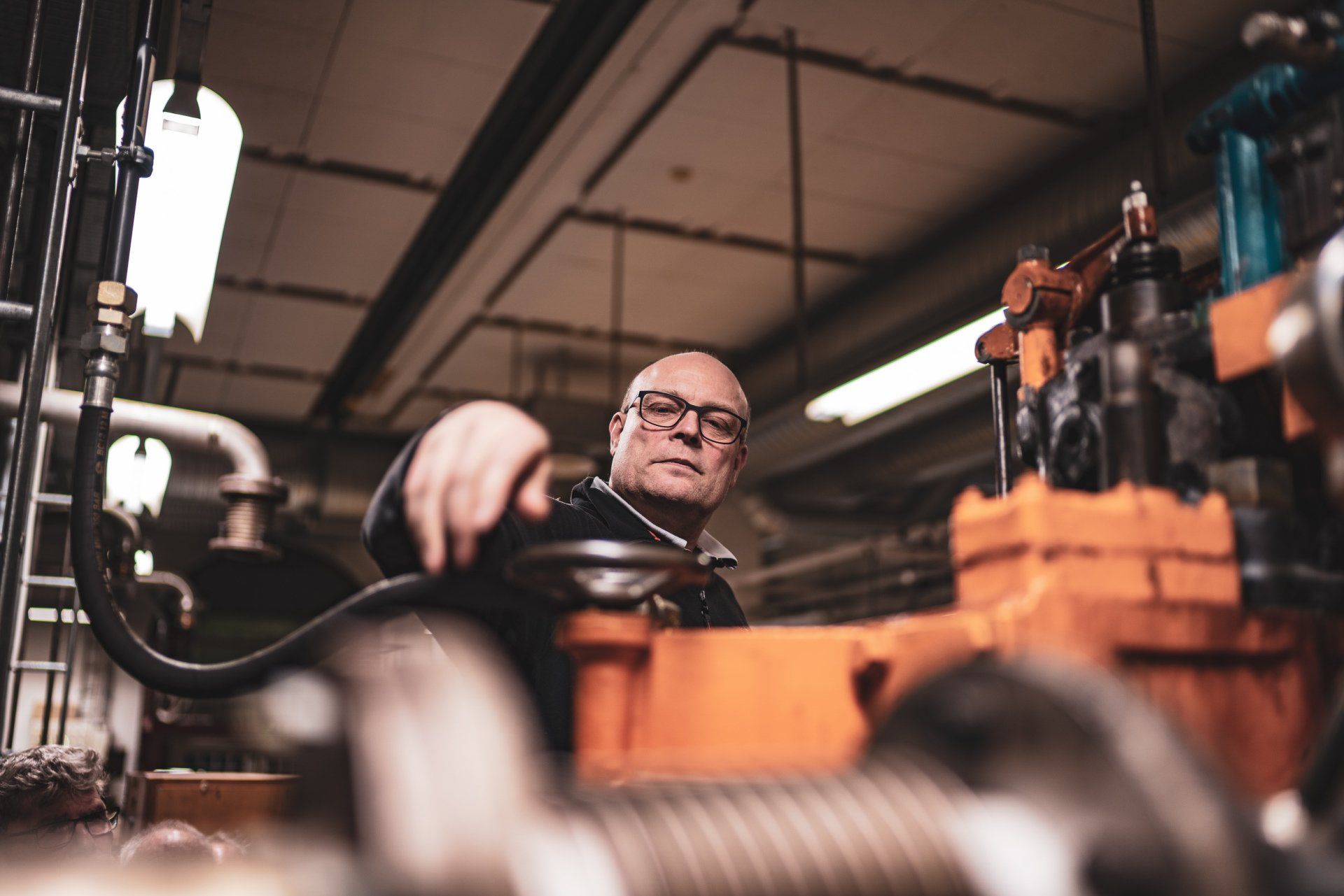 En mand arbejder på en maskine på en fabrik.
