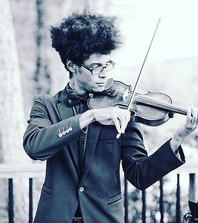 A man in a suit and bow tie is playing a violin.