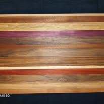 Wooden cutting board with horizontal stripes of various wood colors.
