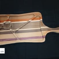 Wooden serving board with striped design and heart-shaped handle.