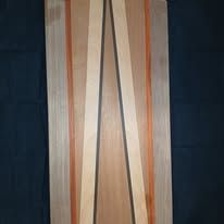 Wooden door with vertical stripes in shades of brown, beige, and orange.