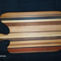 Wooden cutting board with horizontal stripes of various wood colors.