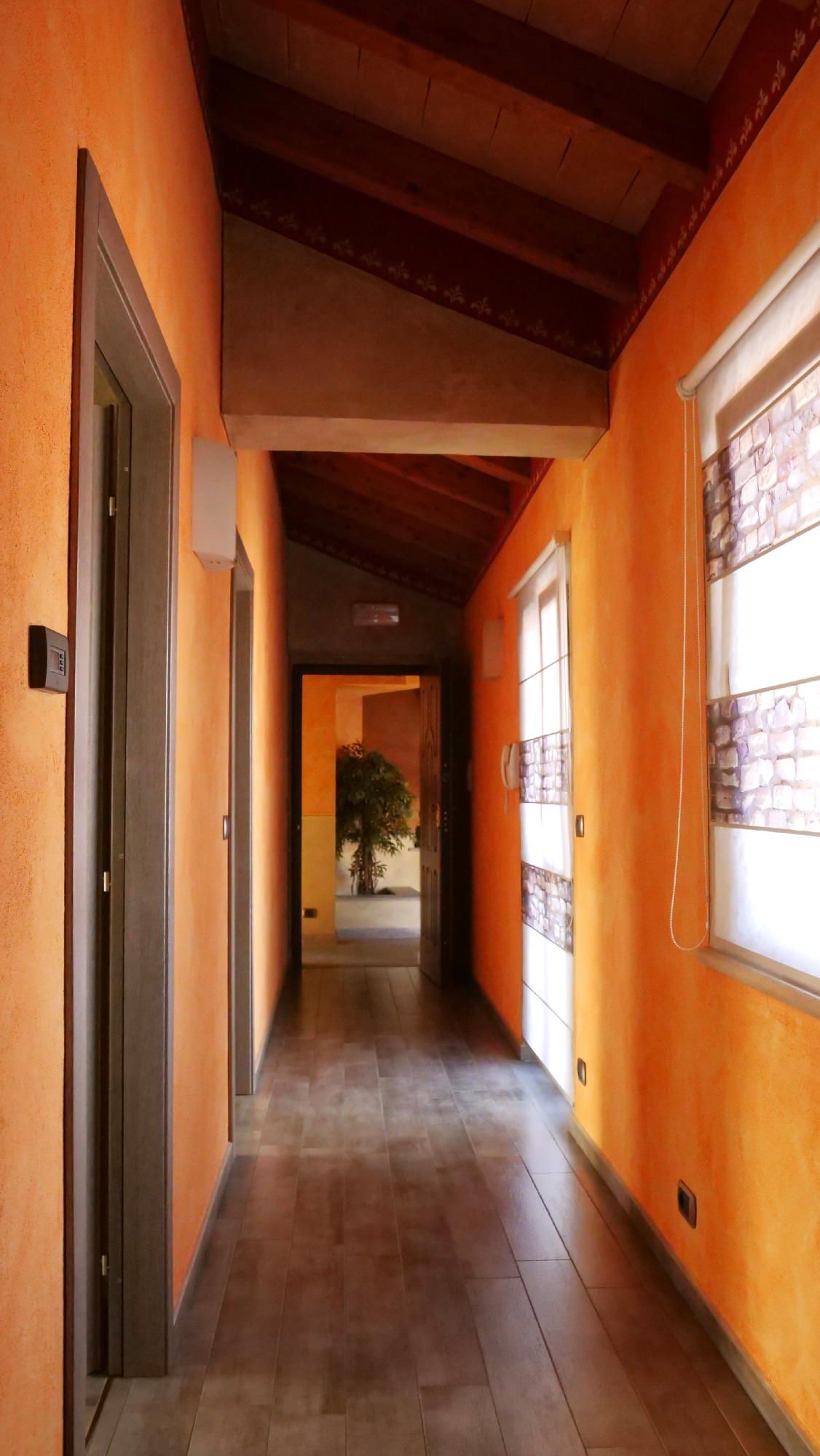 Un lungo corridoio con pareti arancioni e pavimenti in legno