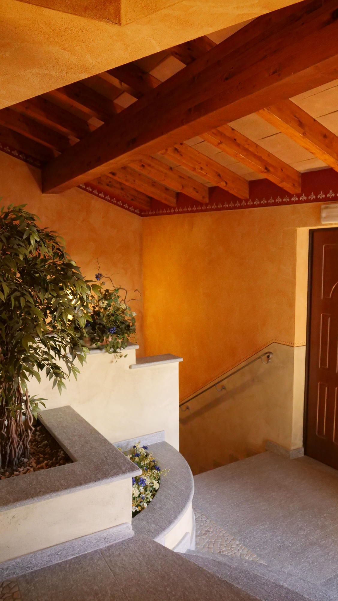 Una scala con un soffitto in legno e una pianta al centro.