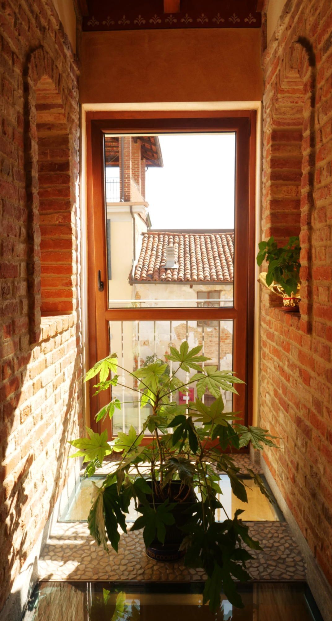 Una pianta in vaso è posizionata nel corridoio, accanto a una finestra.