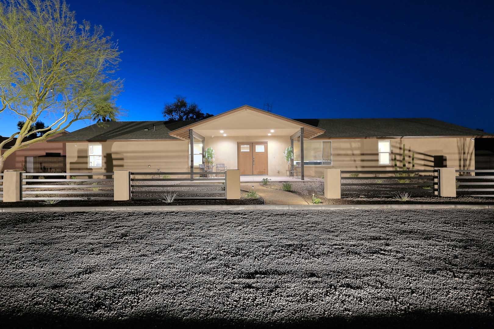 Night-Front View-min A house with a fence and a tree in front of it at night