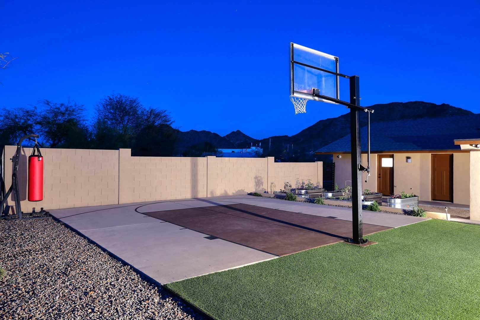 Night-Sport Court-min A basketball hoop is in the backyard of a house