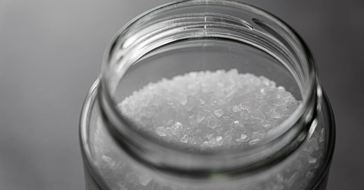 A glass jar filled with white sugar on a table.