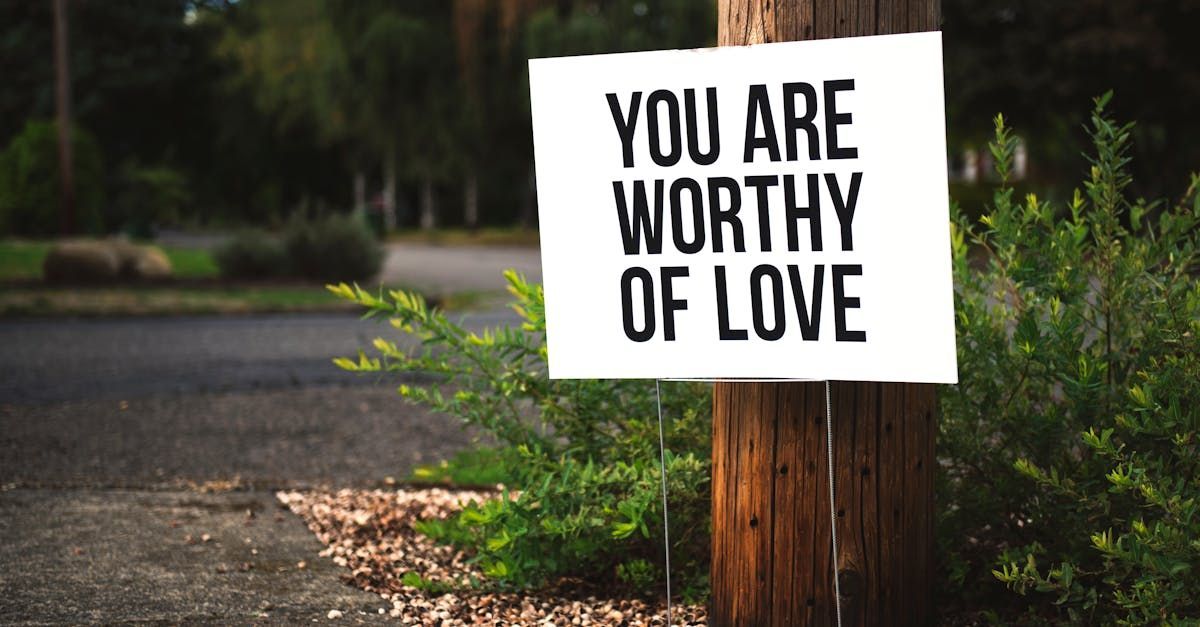 A sign on a wooden pole that says `` you are worthy of love ''.