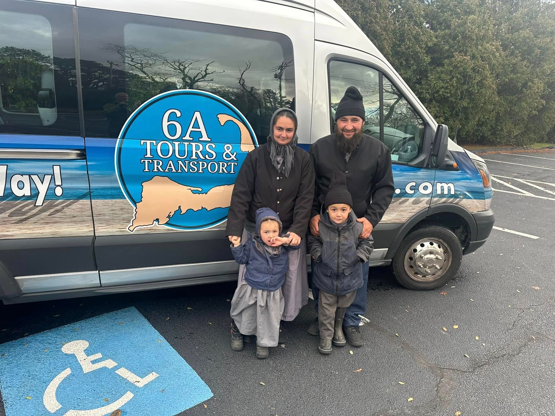 Family stands in front of a tour van with a company logo. A wheelchair symbol is visible.