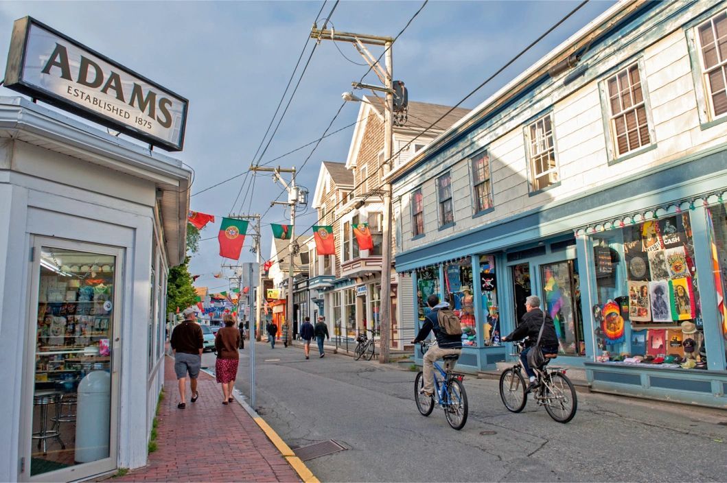 Interior view of a gallery space with an arched doorway. White walls, wooden floor, artwork displayed.