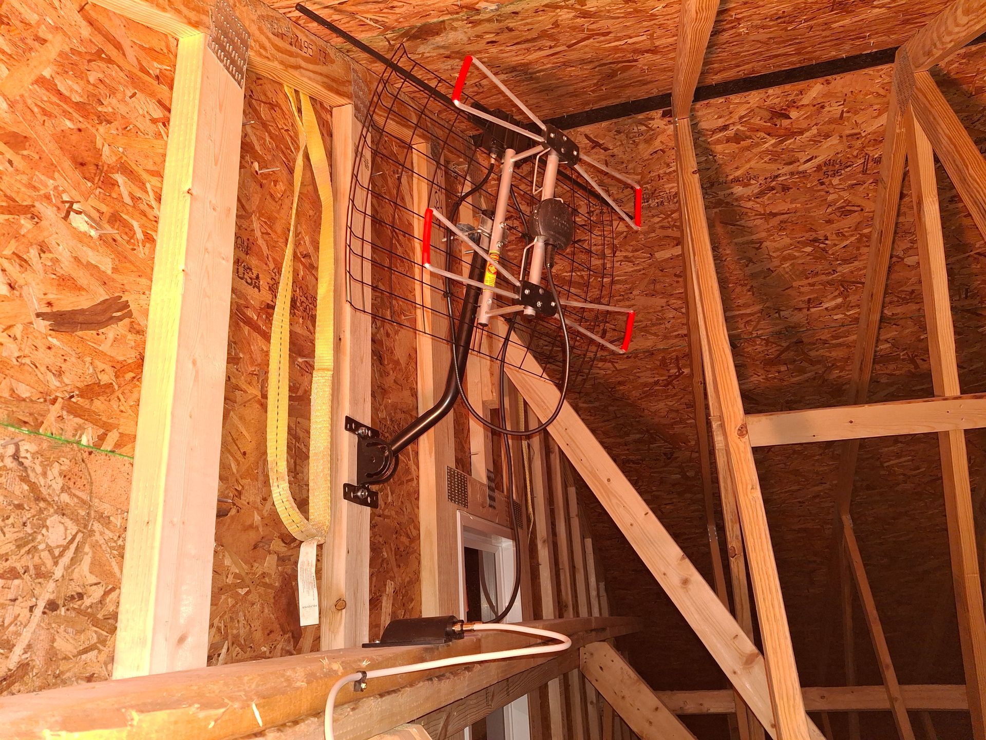 A satellite dish is hanging from the ceiling of a building under construction