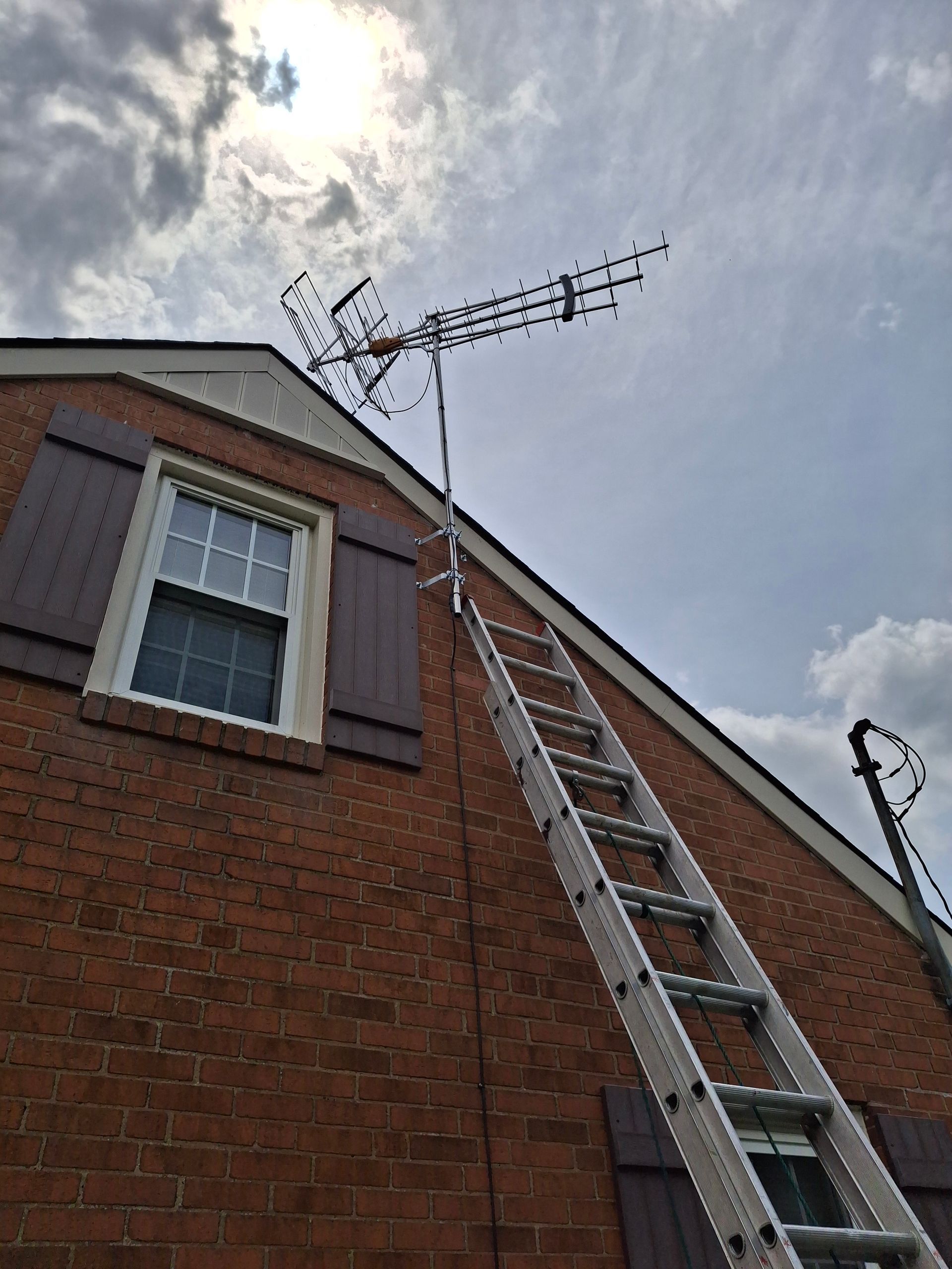 A ladder is attached to the side of a brick building.