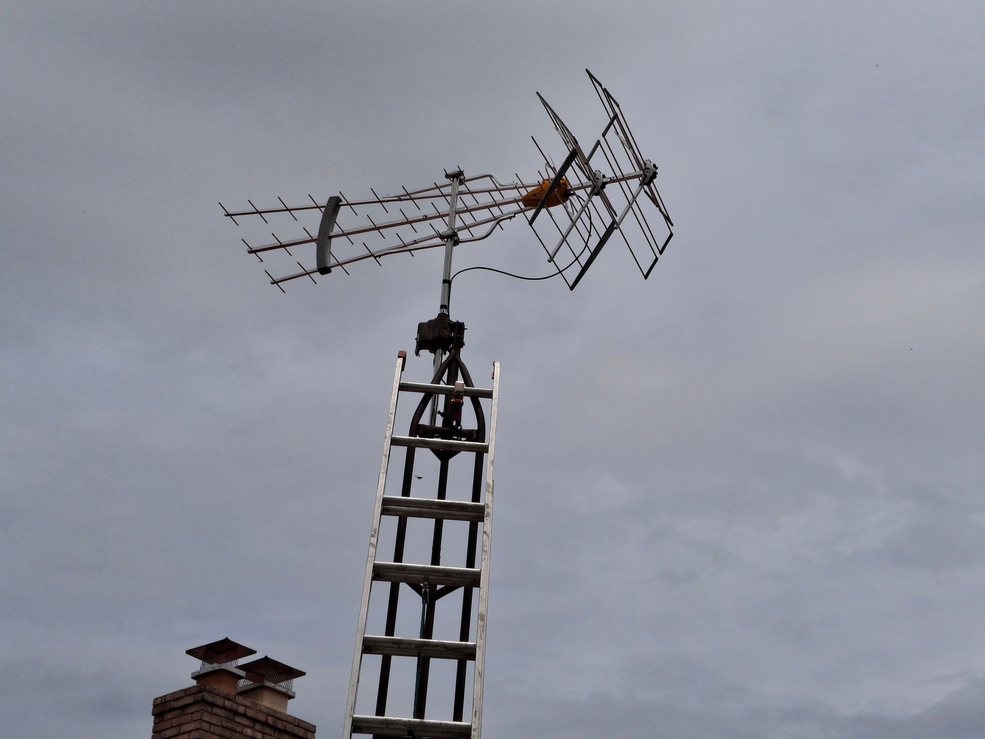 A ladder is attached to an antenna on top of a building