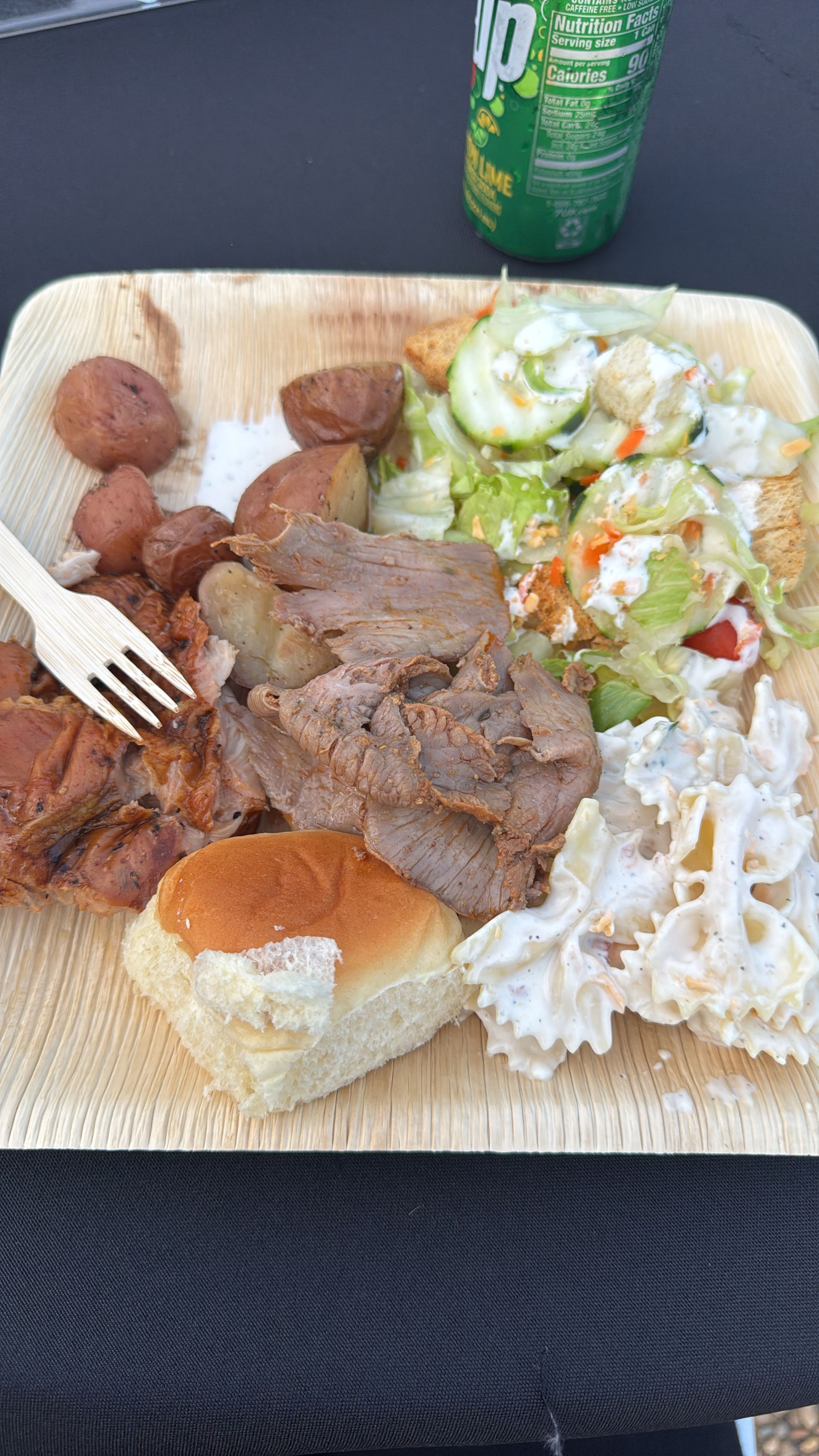 Dinner plate featuring tri-tip, roasted potatoes, salad, pasta salad, and a dinner roll served at the Oroville Economic Alliance Annual BBQ.