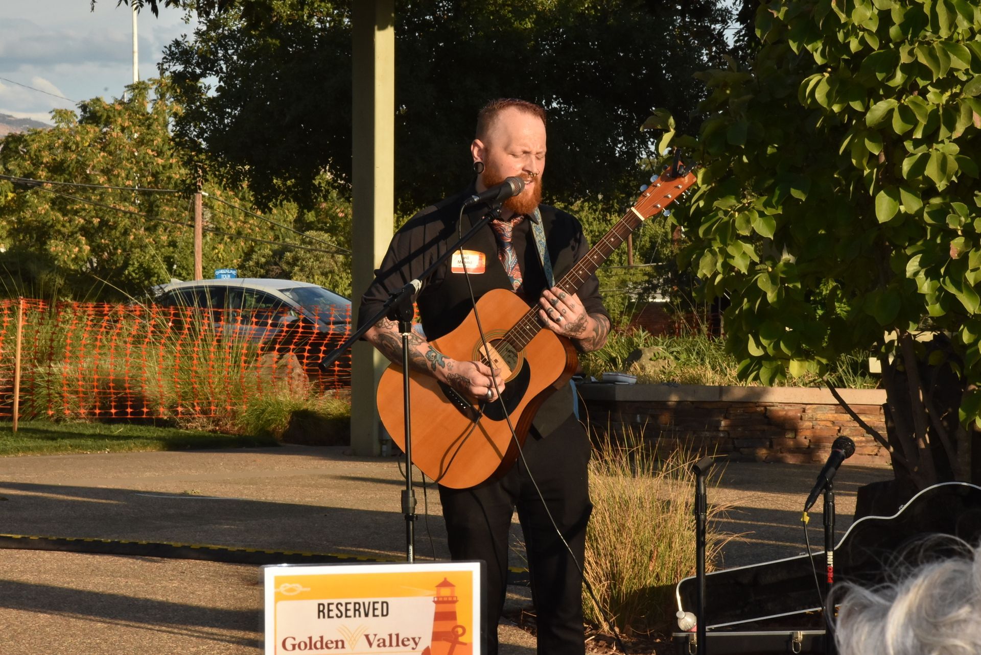 Musician performing live acoustic guitar set on stage during the Oroville Economic Alliance Annual BBQ at sunset.