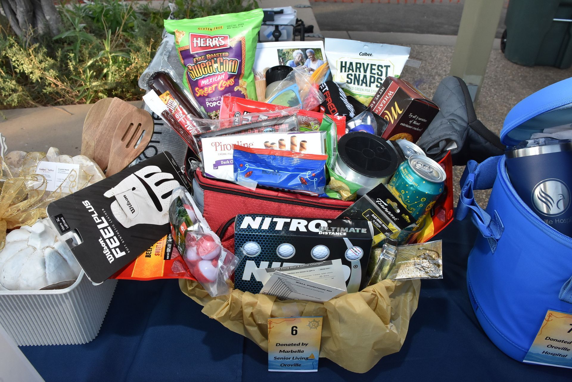 Colorful raffle prize basket filled with snacks, drinks, and small gifts donated by local sponsors at the Oroville Economic Alliance Annual BBQ.